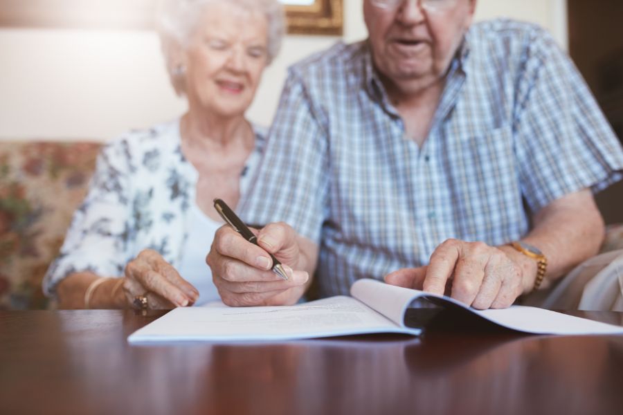 pareja de ancianos firmando testamento